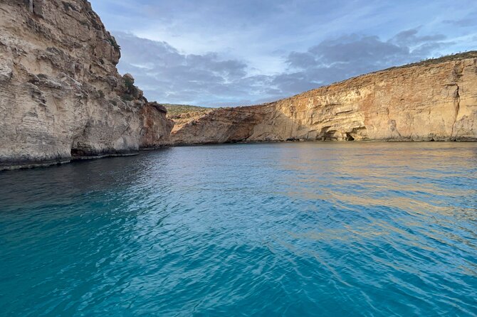 Blue Lagoon Ferry and Caves Tour - Meeting Under the Blue Umbrella in Mgarr