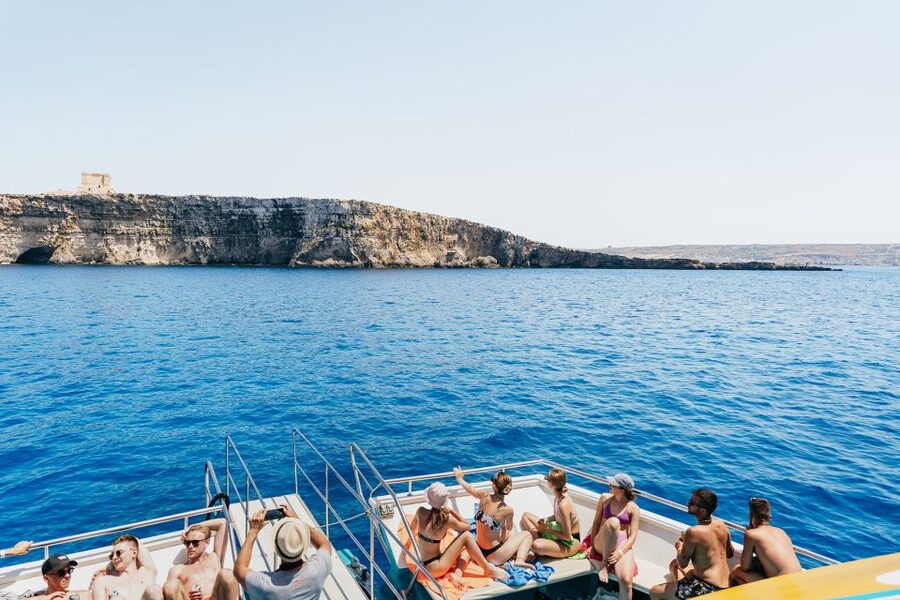 Comino: Blue Lagoon, Crystal Lagoon, and Seacaves Tour - Blue Lagoon, beautiful water with a busy shoreline
